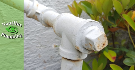 Close-up of a natural gas pipe entering a home, with shutoff valve for use during earthquakes