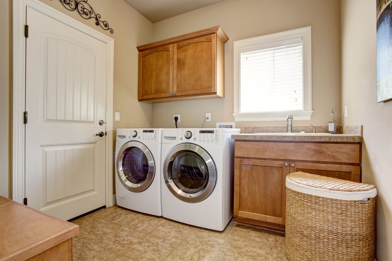 Laundry room with wooden cabinets and white full size washer and dryer