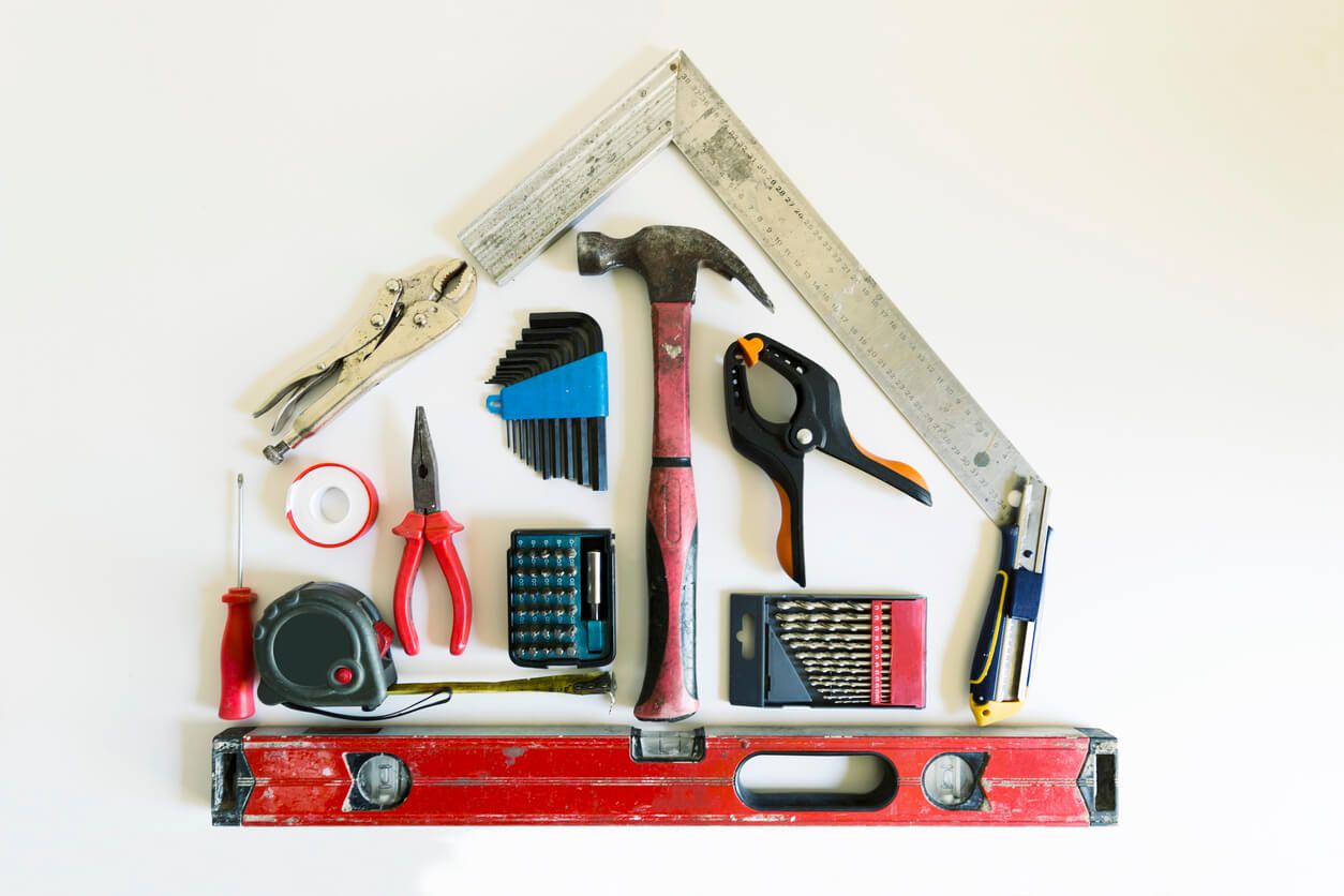 Plumbing tools, including a hammer, clamp, pliers, screwdriver, drill bits, pliers, a ruler, and measuring tape
